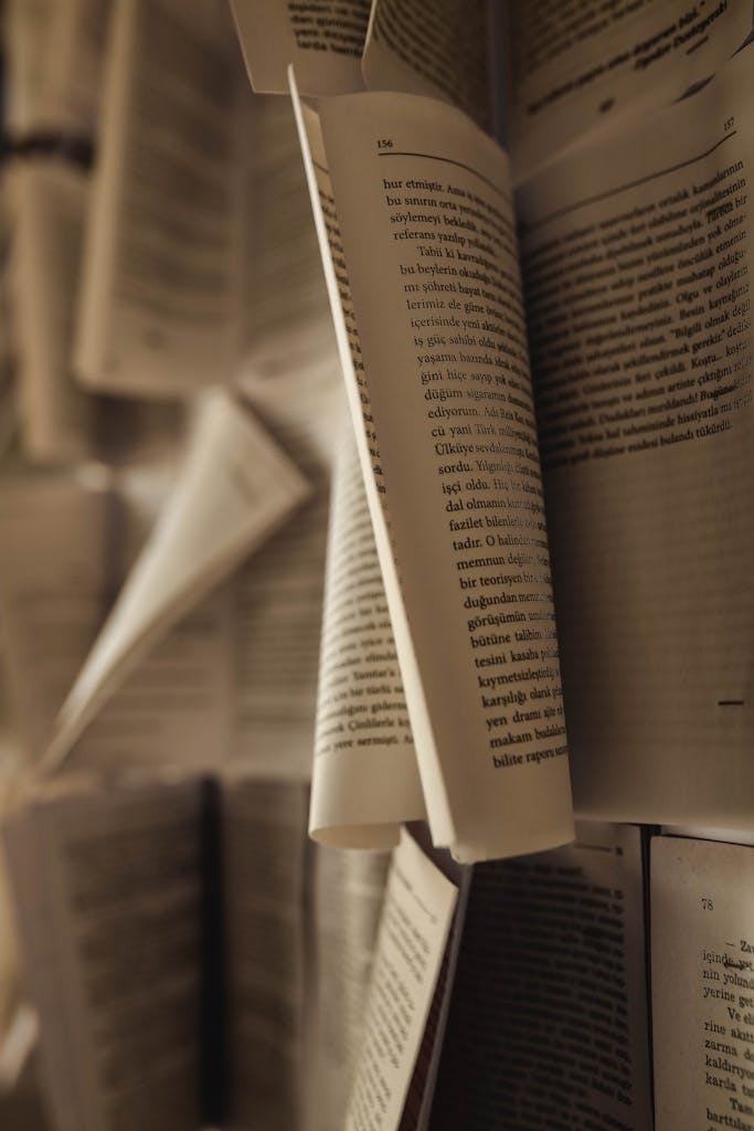 Artistic close-up of open book pages in motion, highlighting the texture and depth of paper.